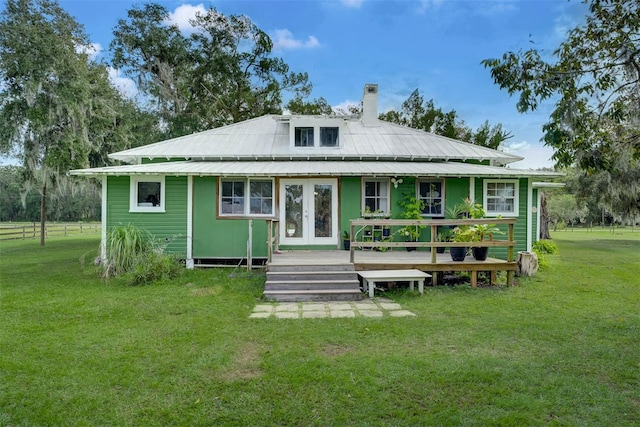 back of property featuring a wooden deck, french doors, and a yard