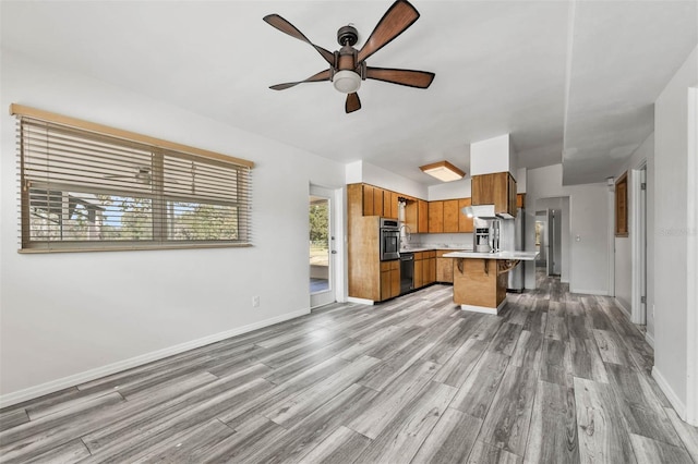 kitchen with black dishwasher, ceiling fan, light hardwood / wood-style floors, and oven