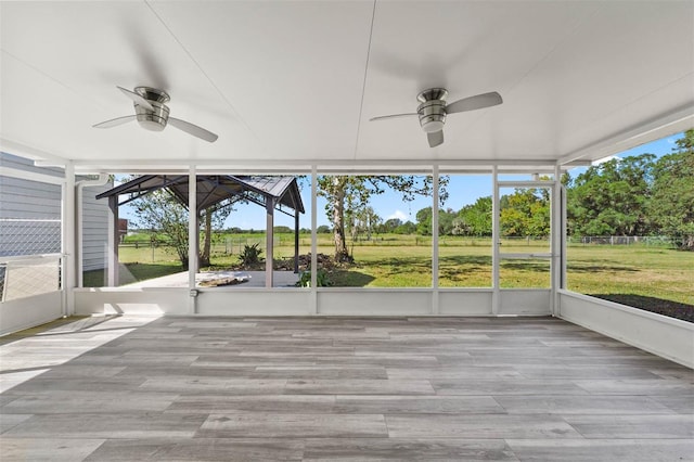 unfurnished sunroom with a healthy amount of sunlight and ceiling fan