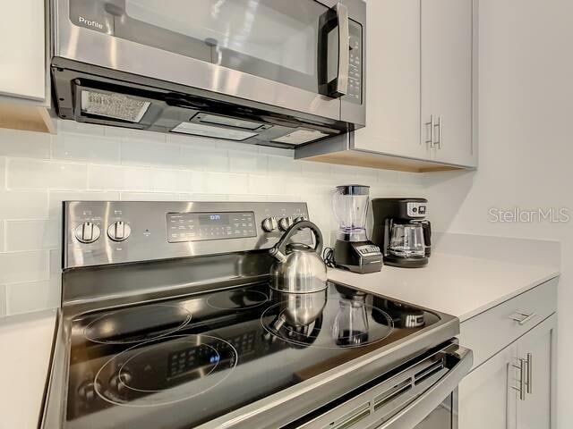 kitchen with white cabinetry, stainless steel appliances, and decorative backsplash