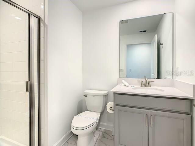 bathroom with vanity, toilet, and walk in shower