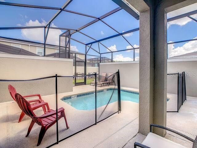 view of swimming pool with a patio area and a lanai