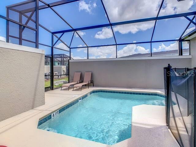 view of swimming pool featuring a patio and glass enclosure