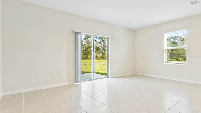 tiled spare room with a healthy amount of sunlight