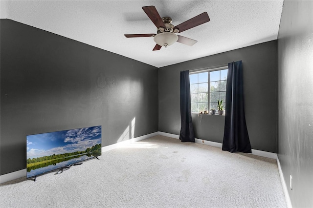 spare room featuring light carpet, a textured ceiling, and ceiling fan