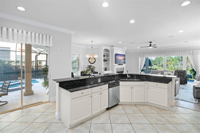 kitchen with light tile patterned floors, hanging light fixtures, sink, white cabinets, and dishwasher