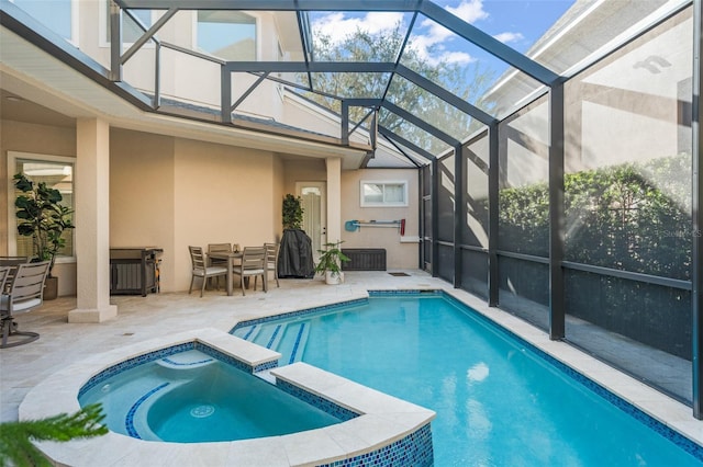 view of swimming pool featuring a patio, glass enclosure, and an in ground hot tub