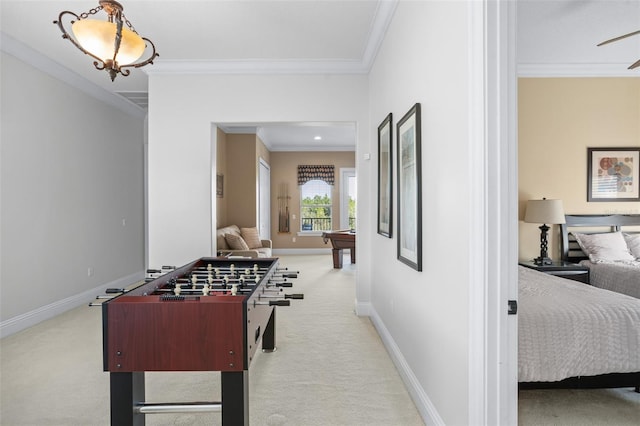 recreation room featuring ceiling fan, light carpet, and crown molding