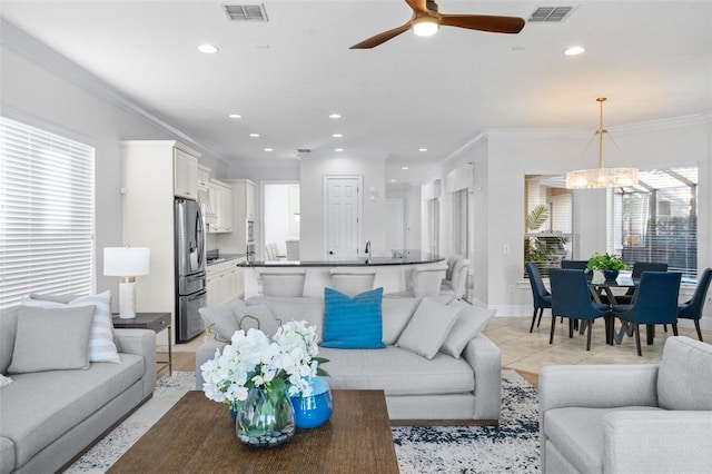 tiled living room featuring ceiling fan with notable chandelier and crown molding