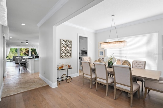 dining room with ornamental molding, light wood-type flooring, and ceiling fan