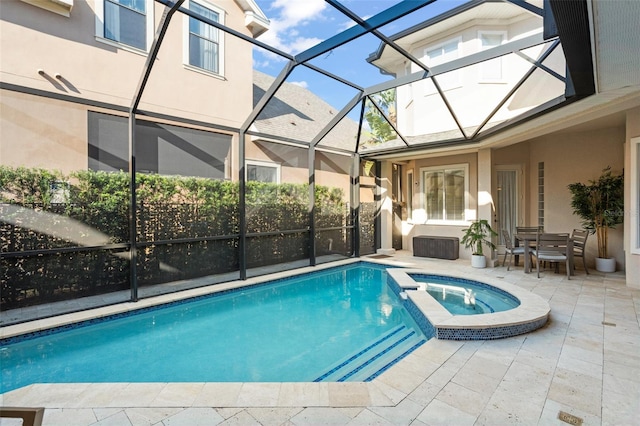 view of swimming pool with glass enclosure, a patio, and an in ground hot tub