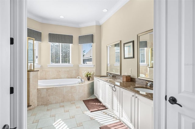 bathroom featuring vanity, tiled tub, crown molding, and plenty of natural light