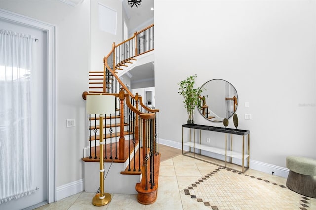 stairs featuring tile patterned floors and crown molding