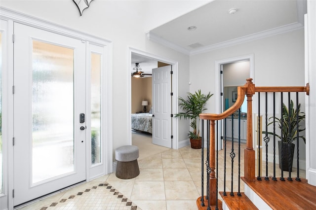 foyer featuring a wealth of natural light, light tile patterned floors, and ornamental molding