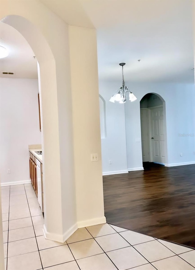 corridor featuring a notable chandelier and light hardwood / wood-style flooring