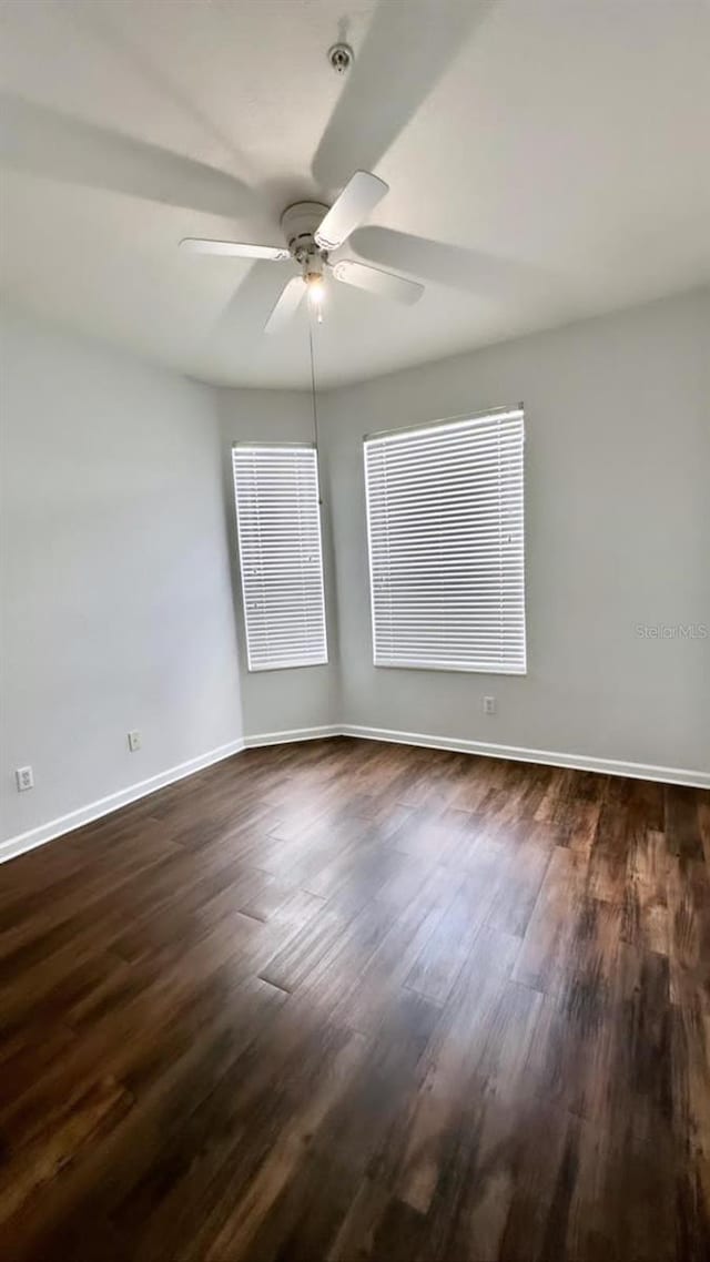 unfurnished room with ceiling fan and dark hardwood / wood-style flooring