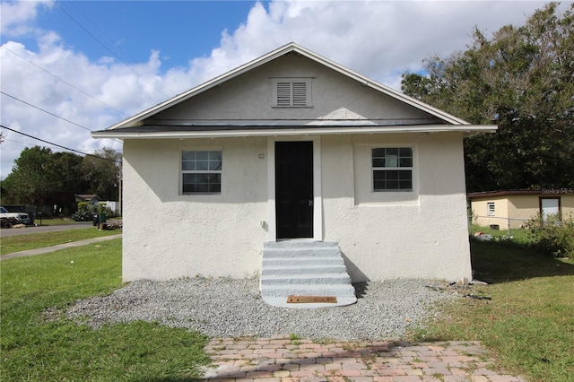 828 Willie Mays Pkwy, Orlando, FL 32811 - bungalow-style home with entry steps, stucco siding, and a front lawn