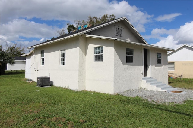 exterior space with central AC and a lawn