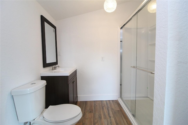 bathroom with walk in shower, wood-type flooring, vaulted ceiling, toilet, and vanity