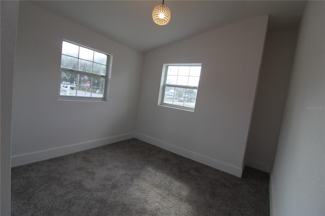 carpeted empty room featuring lofted ceiling