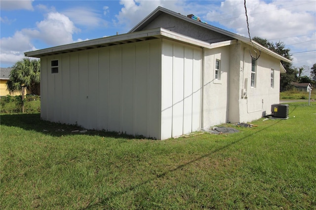 view of side of home featuring a yard and central AC unit