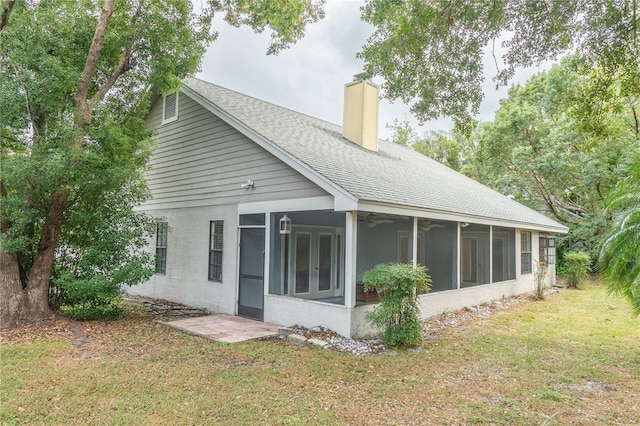 rear view of property featuring a lawn and a sunroom