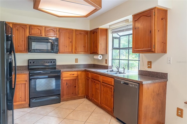 kitchen featuring black appliances, light tile patterned flooring, and sink