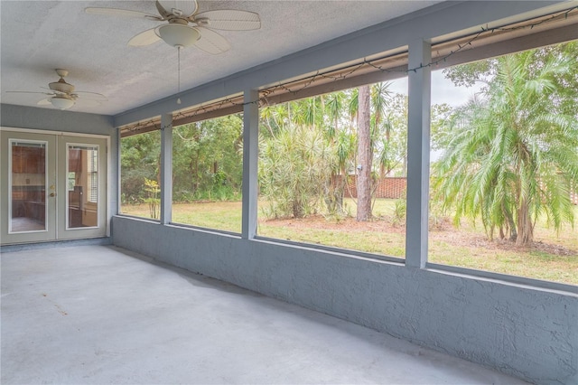 unfurnished sunroom featuring ceiling fan, french doors, and a wealth of natural light