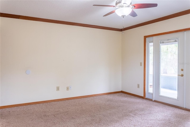 spare room with ceiling fan, crown molding, and carpet