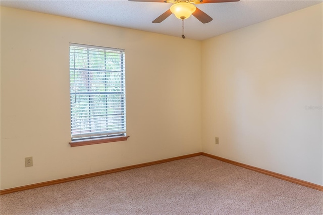 carpeted spare room featuring ceiling fan