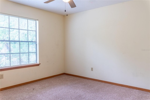 carpeted spare room with ceiling fan