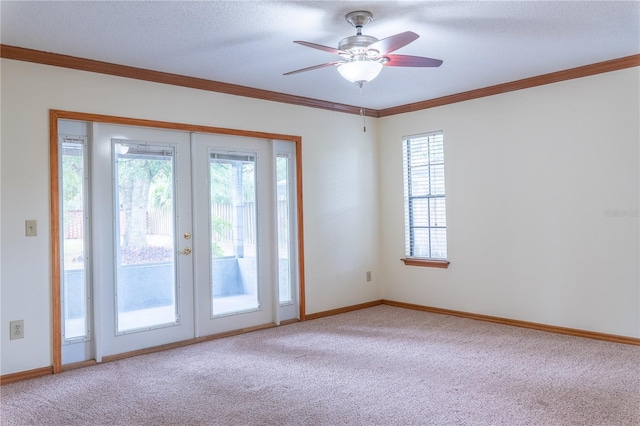 empty room with ceiling fan, carpet floors, french doors, and crown molding