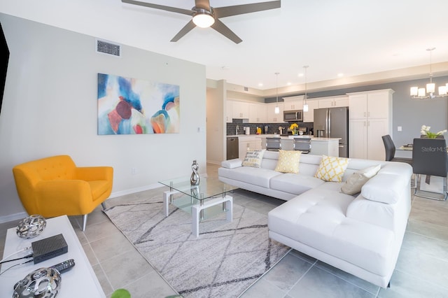 living room featuring ceiling fan with notable chandelier