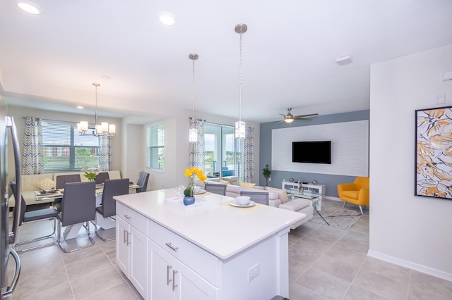 kitchen with white cabinetry, a wealth of natural light, decorative light fixtures, and a kitchen island