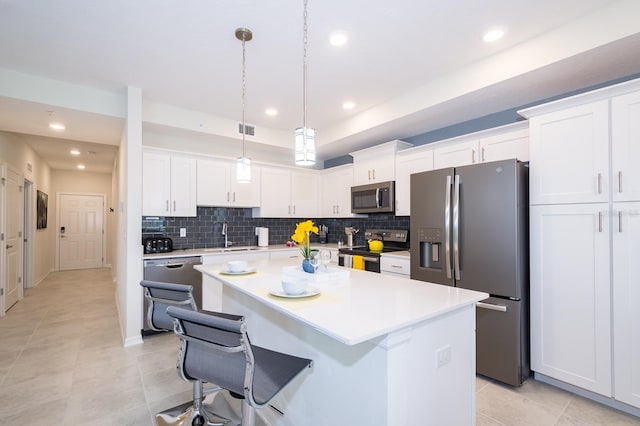 kitchen with white cabinets, decorative light fixtures, and stainless steel appliances