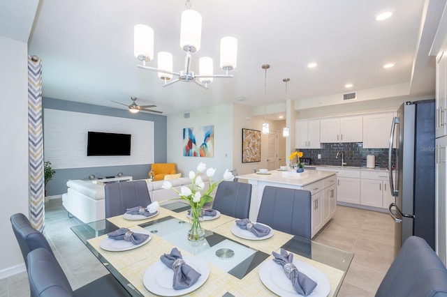 dining area with sink, ceiling fan with notable chandelier, and light tile patterned floors