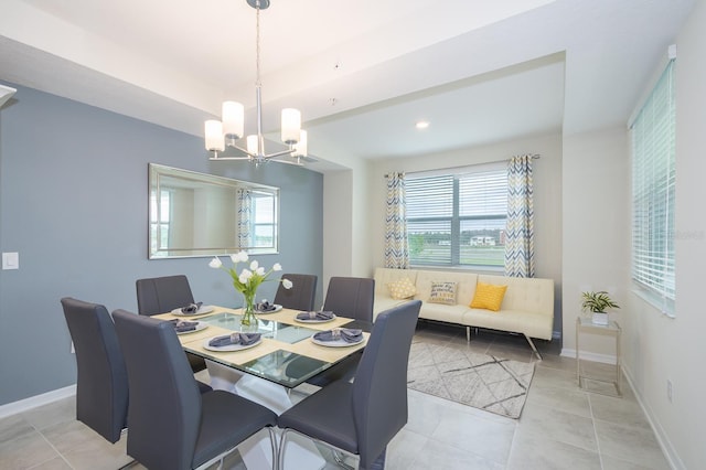 tiled dining room featuring a chandelier