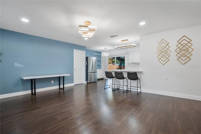 1213 Baranova Rd, Ocoee, FL 34761 - kitchen featuring freestanding refrigerator, a breakfast bar, a peninsula, white cabinetry, and light countertops