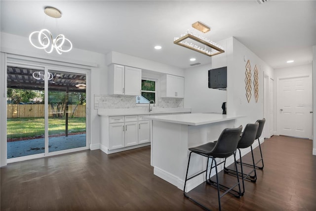 kitchen featuring white cabinetry, hanging light fixtures, and dark hardwood / wood-style floors