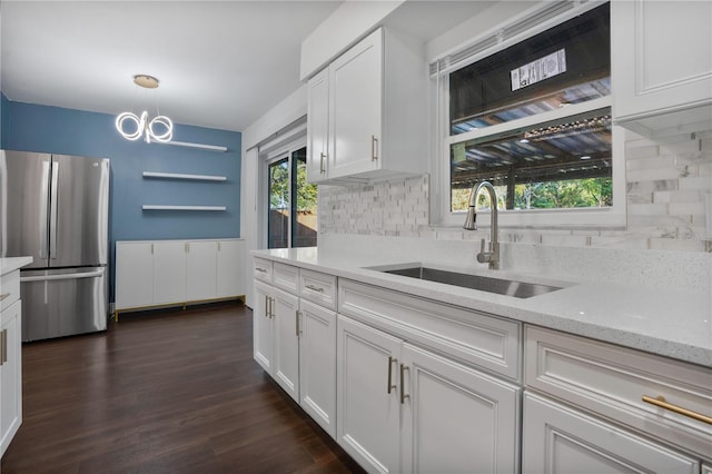 kitchen featuring sink, backsplash, dark hardwood / wood-style flooring, stainless steel fridge, and white cabinets