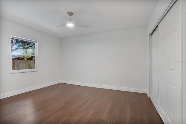 unfurnished bedroom featuring dark wood-type flooring, a closet, and ceiling fan