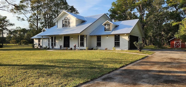 view of front of home with covered porch, a garage, and a front lawn