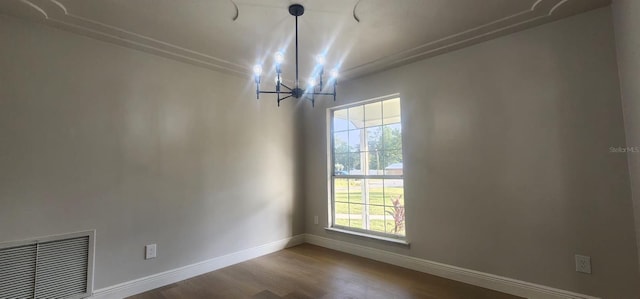 unfurnished dining area with wood-type flooring, ornamental molding, a wealth of natural light, and an inviting chandelier