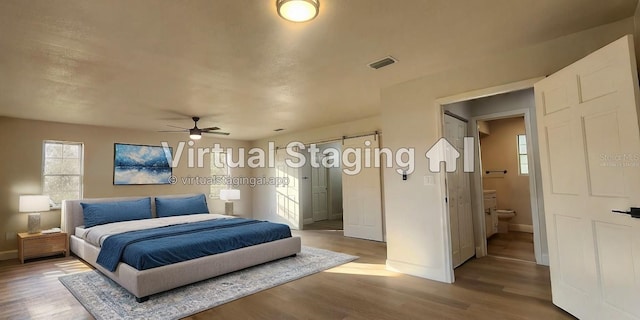 bedroom with hardwood / wood-style floors, ceiling fan, and ensuite bath