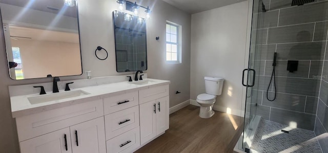 bathroom with hardwood / wood-style floors, vanity, an enclosed shower, and toilet