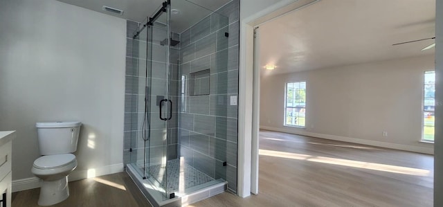 bathroom with walk in shower, ceiling fan, wood-type flooring, and toilet