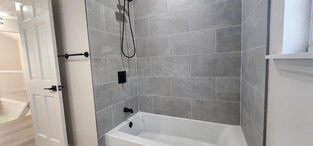 bathroom with wood-type flooring and tiled shower / bath