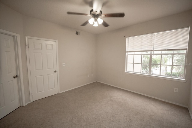 unfurnished room featuring ceiling fan and carpet floors