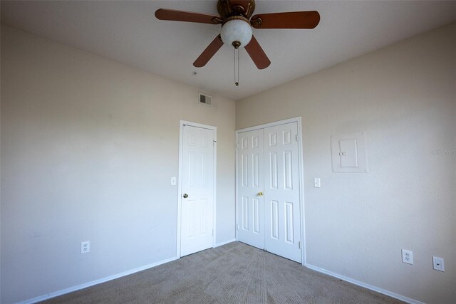 unfurnished bedroom with carpet, a closet, and ceiling fan