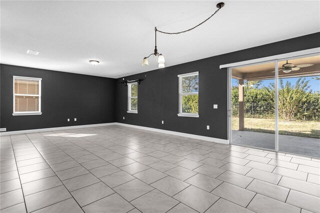 tiled spare room featuring ceiling fan and a healthy amount of sunlight